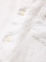 Camisa de lino verde militar, de manga larga con cuello clásico y bolsillo en el pecho. Cierre frontal con botones.