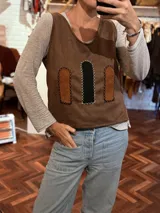 Chaleco marrón de tela agamuzada con apliques cortados y bordados a mano. Diseño sin mangas con cuello en V.