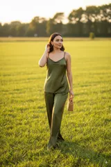 Conjunto de pantalón palazzo y musculosa lencera color verde oliva. El pantalón es de corte recto con elástico en la cintura y la musculosa tiene tirantes finos y escote con caída.