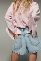 Camisa blanca de modal con cuello solapa, manga larga con puños abotonados, cierre frontal con botones y dos bolsillos con solapa en el pecho.