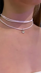Gargantilla choker blanca de doble tira con dije de corazón plateado.