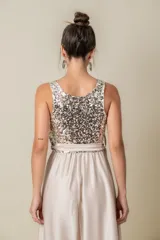 Vestido largo de fiesta color champagne, con corpiño de lentejuelas plateadas, falda de satén liso y lazo de satén en la cintura. Corsé de tul bordado. Talle único adaptable de S a L.