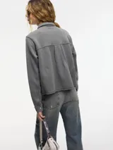 Sobrecamisa gris con broches metálicos en la parte delantera, bolsillo con solapa y cuello camisero.