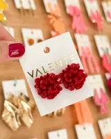 Par de aros con forma de flor roja con textura.