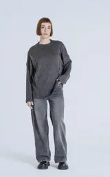 Sweater gris oscuro de corte recto, cuello redondo y mangas largas con detalle de costuras a los lados.
