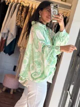 Camisa celeste con estampado abstracto, de corte amplio, cuello camisero y mangas largas abullonadas con puños elásticos.