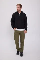 Sweater negro de punto con cuello alto y cierre de cremallera parcial.