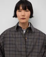 Gabardina larga a cuadros con cuello solapa, manga japonesa y cierre con botones.