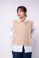 Chaleco color beige de tejido rústico con lazos laterales.