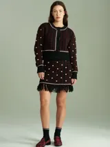 Cardigan de punto color borgoña con diseño geométrico en blanco y detalles en azul. Tiene cuello redondo, cierre frontal con botones rojos y mangas largas con puños acanalados.