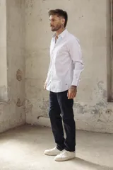 Camisa blanca de corte slim fit, manga larga y cuello clásico. Cierre frontal con botones.