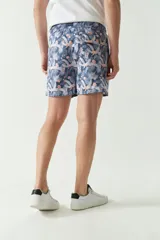 Short de baño celeste con estampado de hojas, cintura elástica con cordón ajustable, dos bolsillos laterales y uno trasero.