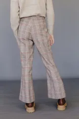 Pantalón acampanado con estampado a cuadros en tonos marrón, beige y rojo.