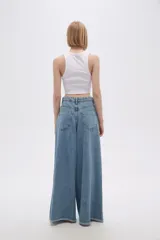 Pantalón de jean celeste de corte palazzo, tiro alto y ruedo desflecado.