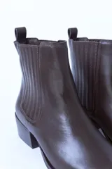 Botines Chelsea de cuero color marrón oscuro, con elástico lateral y tacón bajo.