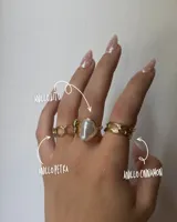 Set de tres anillos dorados. Uno con eslabones, otro con una perla irregular y el tercero con diseño de líneas horizontales.