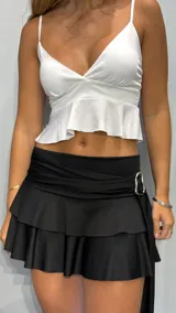 Top blanco con breteles finos, escote en V y volados en el ruedo.