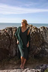 Vestido largo midi de tejido de punto color azul marino, con escote en V profundo y sisas profundas. La parte inferior presenta un calado tipo red.