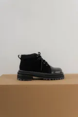 Borcegos negros de cuero charol, con punta cuadrada, cordones y suela track.