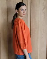 Blusa color rosa con mangas 3/4 y cuello redondo.