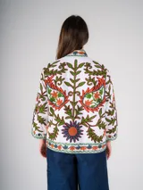 Chaqueta blanca de algodón con bordado floral multicolor de estilo Suzani. Tiene cuello mao, mangas 3/4 y cierre frontal con botones.