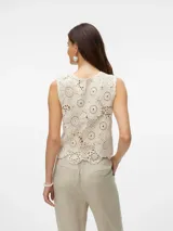 Top sin mangas color blanco roto, tejido a crochet con motivos circulares y borde festoneado.