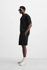 Camiseta negra de corte holgado, con cuello redondo y mangas cortas.