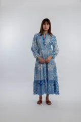 Vestido midi de corte amplio con estampado floral en tonos azules y blancos. Tiene cuello mao con botones y mangas largas abullonadas.