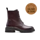 Bota de cuero color marrón con cordones, caña media y suela track negra.