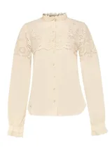 Blusa beige de algodón orgánico con cuello alto y detalles de broderie en la parte superior.