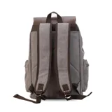 Mochila negra de tela canvas con detalles en símil cuero marrón, cierre superior marinero, bolsillos internos y externos con cierre metálico, asas rígidas y correas ajustables.