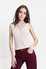 Musculosa de punto color blanco hueso, con escote en V tanto en el frente como en la espalda, y un calce ligero.