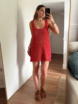 Vestido corto de tejido de punto color beige/dorado, con escote redondo y tirantes anchos. Presenta un tejido acanalado verticalmente con hilos de lurex que le dan brillo.