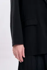 Blazer negro de lyocel con solapas clásicas, corte recto y bolsillos delanteros.