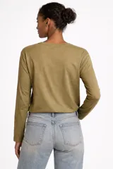 Remera de manga larga confeccionada en algodón de color blanco, con cuello redondo y un bolsillo aplicado en el pecho. Presenta un diseño de calce al cuerpo.