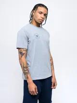 Remera gris de mangas cortas con cuello redondo y logo estampado en el pecho.
