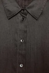 Camisa marrón de corte recto, con cuello solapa, manga corta y cierre frontal con botones.