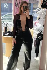 Body negro de lycra, puntilla elastizada y tul, con mangas largas y transparencia en el escote.