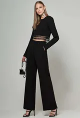Conjunto de blusa cropped de manga larga con bordado y pantalón de tiro alto, ambos en color negro.