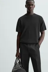 Camiseta negra de corte recto y manga corta, tejida en punto perlado de algodón.