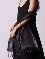 Pashmina negra plisada con detalles de lurex plateado y flecos en los extremos.