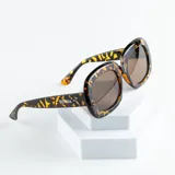 Lentes de sol Benna modelo Uno con montura gruesa de carey y lentes marrones.