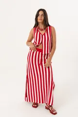 Falda larga tejida a rayas verticales rojas y blancas, con pretina elástica y tajos laterales.