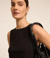 Blusa negra sin mangas confeccionada en crepé con cuello redondo y abotonado delantero.