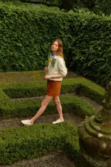 Minifalda marrón de corte evasé, con acabado cepillado suave y costuras decorativas adelante y atrás. Tiene cierre y pretina prolongada con botón a presión.