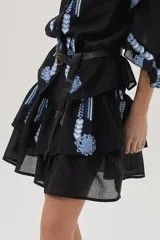 Minifalda blanca con doble volado y bordados florales en tonos naranja y marrón.