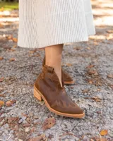 Botines de cuero vacuno color blanco con diseño bordado, taco de madera foliado en cuero de 5cm, cierre del lado interior y horma de punta fina.