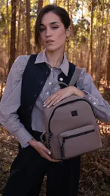 Mochila color topo de neopreno con cierres negros, asa de mano y correas regulables.