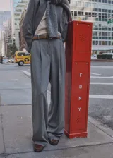 Pantalón de vestir gris de lana virgen, corte wide leg, tiro medio, con trabillas y bolsillos laterales.