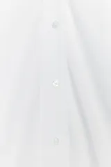 Camisa blanca de algodón con cuello bobo, manga larga con puños y cierre frontal con botones.